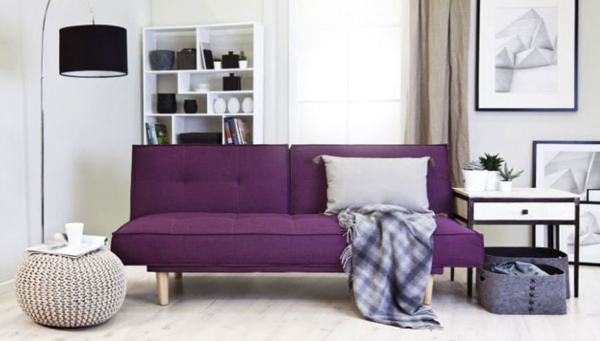 Canapé violet dans salon aux tons clairs